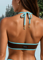 Bikini top with blue straps and visible brand logo against a natural background