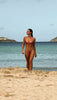 Model Brit Manuela wearing Violaa Swimwear's Tropical Kiss matching set, walking in slow motion on the beach.